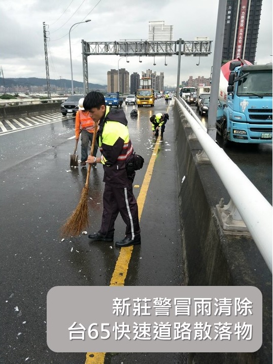 新莊警冒雨清除台65快速道路散落物